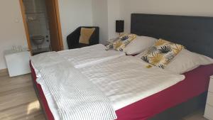 ein großes Bett mit weißer Bettwäsche und Kissen darauf in der Unterkunft Hotel Eigelstein in Köln