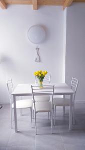 a white table with chairs and a vase of flowers on it at Residenza Solferino in Corniglia