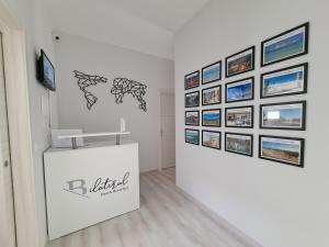 una exposición en una sala blanca con fotos en la pared en Bilateral B&B en Avola