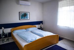 A bed or beds in a room at Nefelejcs Apartmanház