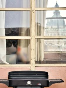 a black suitcase sitting in front of a window at Rumbach Terrace Apartment in Budapest +58 photos