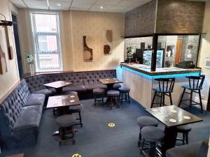 un restaurante con mesas y sillas y un bar en Sherwood Hotel, en Blackpool