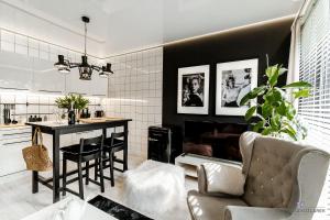 kuchnia i salon ze stołem i kominkiem w obiekcie Apartament Black w mieście Mielno