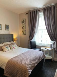 1 dormitorio con cama y ventana grande en The Clovelly en Llandudno