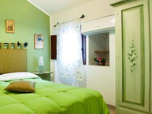 a bedroom with a green bed and a window at Bed And Breakfast Maria in Scopello