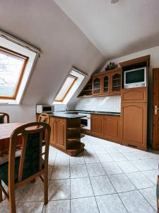 eine Küche mit Holzschränken, einem Tisch und einem TV in der Unterkunft Casa Fiore By BLTN Balatonlelle in Balatonlelle