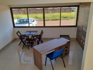 a room with two tables and chairs and a window at Rosa Vilma Hotel in Chapadão do Sul