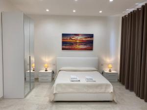 1 dormitorio blanco con 1 cama y 2 mesitas de noche en Villa Cinque, en Vico Equense