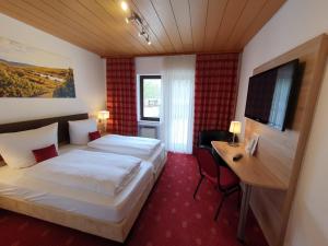 a hotel room with a bed and a desk at Hotel und Weingut Karlsmühle in Mertesdorf