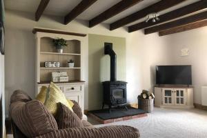 a living room with a couch and a wood stove at The Wee Barn. In the heart of the countryside in Corbet Milltown