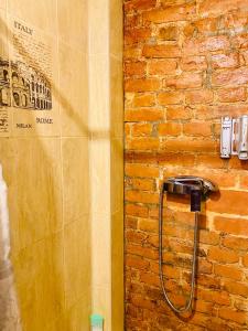 a bathroom with a hose attached to a brick wall at The Isaac Apart in Saint Petersburg