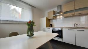 a kitchen with a table with a vase of flowers on it at Am Seewald - Ferienwohnung am Bodensee in Friedrichshafen