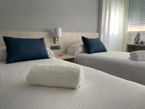 una habitación de hotel con 2 camas y una silla. en LC Hotel Urbano, en Alicante