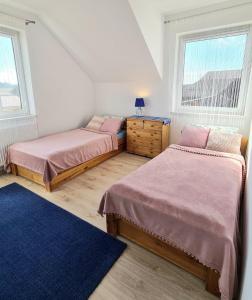two beds in a room with two windows at Rodzinny Apartament na Kaszubach in Brusy +36 photos
