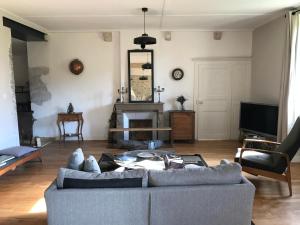 a living room with a couch and a tv at Golf Val de Sorne Vernantois Maison vigneronne in Vernantois