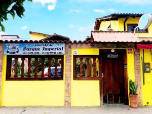 a yellow building with a sign in front of it at Pousada Parque Imperial no centro de Paraty in Paraty