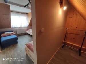a room with two beds and a room with a door at Agroturystyka Pod Kołami in Myczkowce