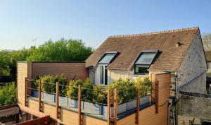 a house with a balcony with plants on it at Gite - L'Oursonnière de Bleau in Saint-Germain-sur-École