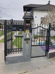 um portão preto com um parquímetro em frente a uma casa em Holiday Home Baotic em Velika Mlaka