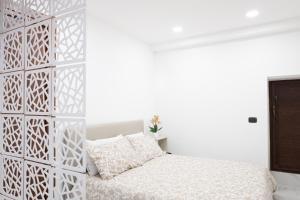 een slaapkamer met een witte muur en een bed bij La Dacha di Ortigia in Siracusa