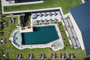 an overhead view of a swimming pool and resort at Wellness und Brunch Hotel MorgenZeit beheizter Naturteich Genuss Frühstück bis 13 Uhr Hochkönig Sommercard in Maria Alm am Steinernen Meer