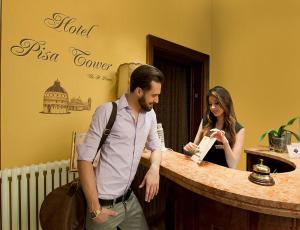 a man standing next to a woman in front of a bar at Hotel Pisa Tower in Pisa