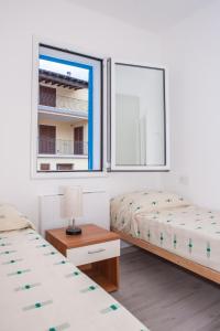- une chambre avec 2 lits et une fenêtre dans l'établissement White & Blue, à Santa Maria Navarrese