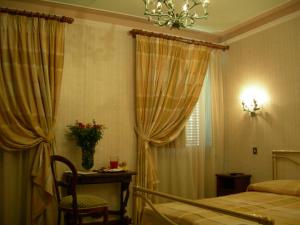 a bedroom with a bed and a table and a window at Hotel Villa San Donino in Città di Castello