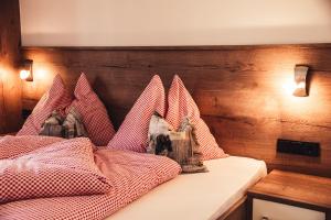 a bedroom with a bed with red and white checkered pillows at Appartement Pointschneiderhof in Maishofen