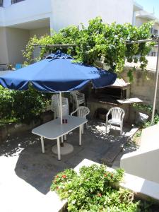 
a patio table with chairs and umbrellas at Michael Apartments in Rethymno
