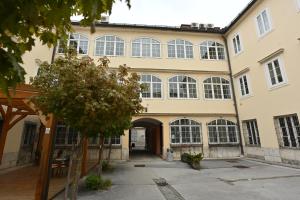 un gran edificio con grandes ventanas y un patio en ATIK ROOMS en Liubliana