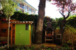 una puerta verde junto a un árbol y una parrilla en La casa di nonno Giulio, en Porto SantʼElpidio