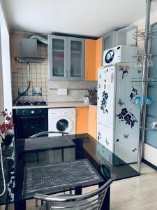 a kitchen with a white refrigerator and a stove at City Centre Apartment on Krylenko 7 in Mogilev