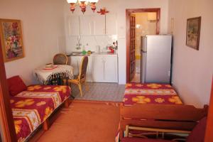 a kitchen with a refrigerator and a table and chairs at Apartments Morski Vuk in Tivat