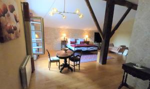 PineuilhにあるLA CARRETERIE - Maison de Famille{s}のテーブルと椅子、リビングルームが備わる客室です。