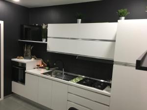 a kitchen with white cabinets and a sink at Luxury House in Letojanni