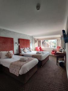 a hotel room with two beds and a desk at The Minster Hotel in York