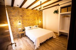 ein Schlafzimmer mit einem Bett und einer Steinwand in der Unterkunft Maremar Suites in Benidorm