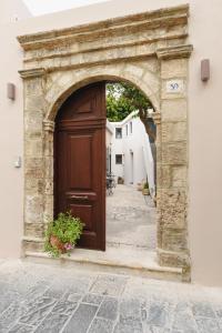 una entrada abovedada a un edificio con una gran puerta de madera en Casa Melenia ''Pilionas'', en Rodas
