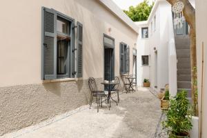 un patio con sillas y una mesa junto a un edificio en Casa Melenia ''Pilionas'', en Rodas