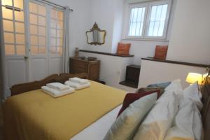 a bedroom with a bed with towels on it at Antique, Amazing double room in Marques de Pombal with shared Bathroom in Lisbon