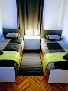 two beds sitting next to each other in a room at Pula Center Arena Belvedere Apartments and Rooms in Pula