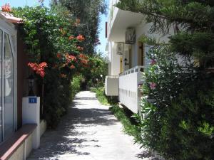 un camino entre dos casas con flores a un lado en Michael Apartments, en Rethymno