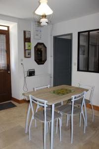 a dining room with a wooden table and chairs at La Mazardie in Cubjac