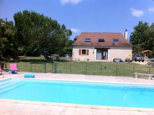 a house and a swimming pool in front of a house at La Mazardie in Cubjac