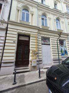 un edificio blanco con una puerta marrón en una calle en The Floor Piata Unirii, en Bucarest