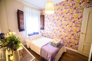 Mały pokój z łóżkiem i kwiatową ścianą w obiekcie Tourist House Santa Maria de Gracia w mieście Carmona +37 zdjęć