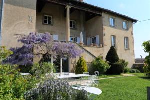 a house with a table and purple flowers in the yard at Domaine David-Beaupère in Juliénas