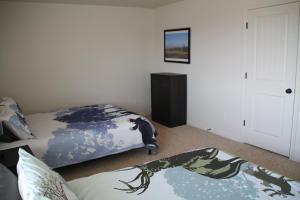 Un dormitorio con una cama con una manta. en 3 queen beds, 1 twin bed, 2 rooms, 1 and a half bath, self check-in, flexcation equipped en Idaho Falls