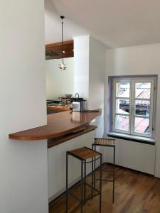 a kitchen with a counter and two bar stools at Oria Lugano Lake, il nido dell'aquila in Oria